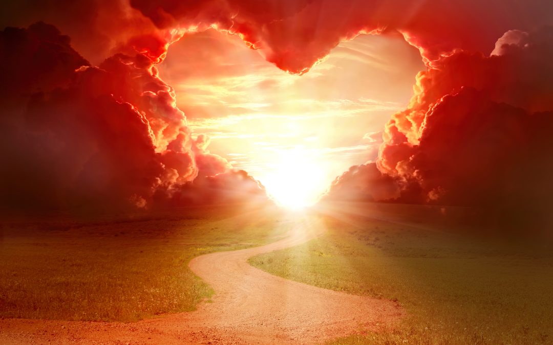 Red heart shaped sky at sunset. Beautiful landscape with road. Love background with copy space. Road to love