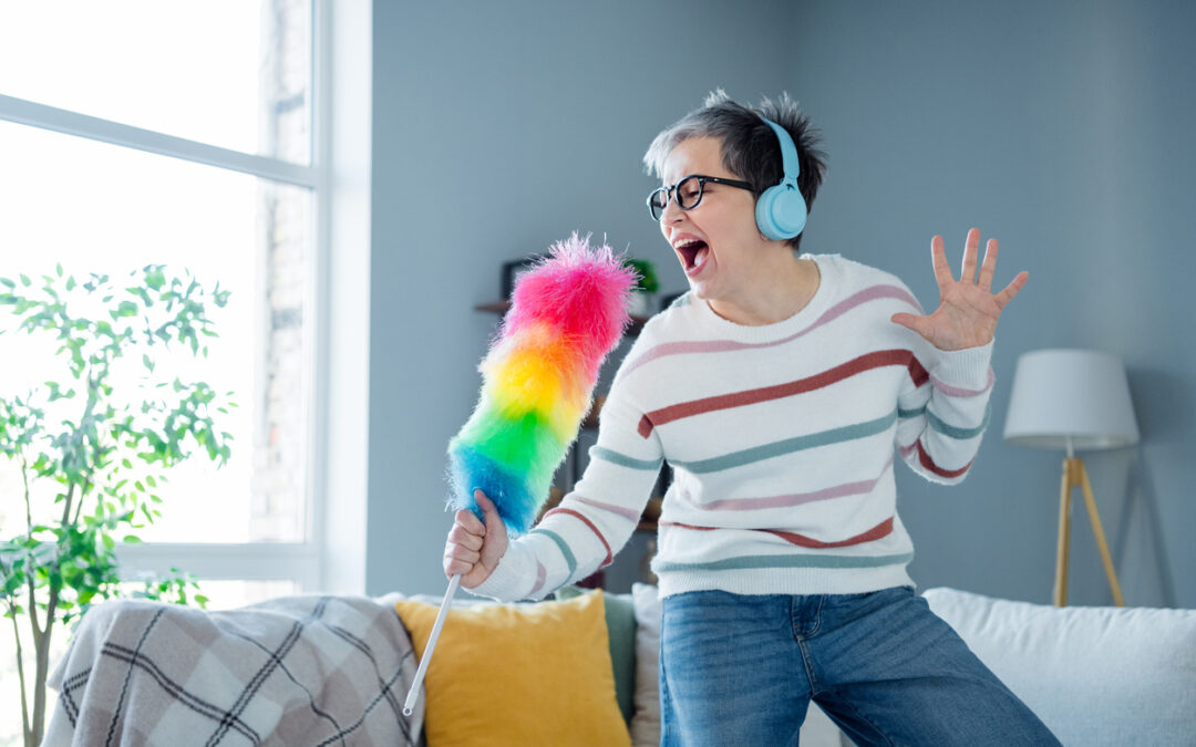 Photo of carefree positive aged person enjoy cleaning listen music headphones sing duster bright interior house indoors