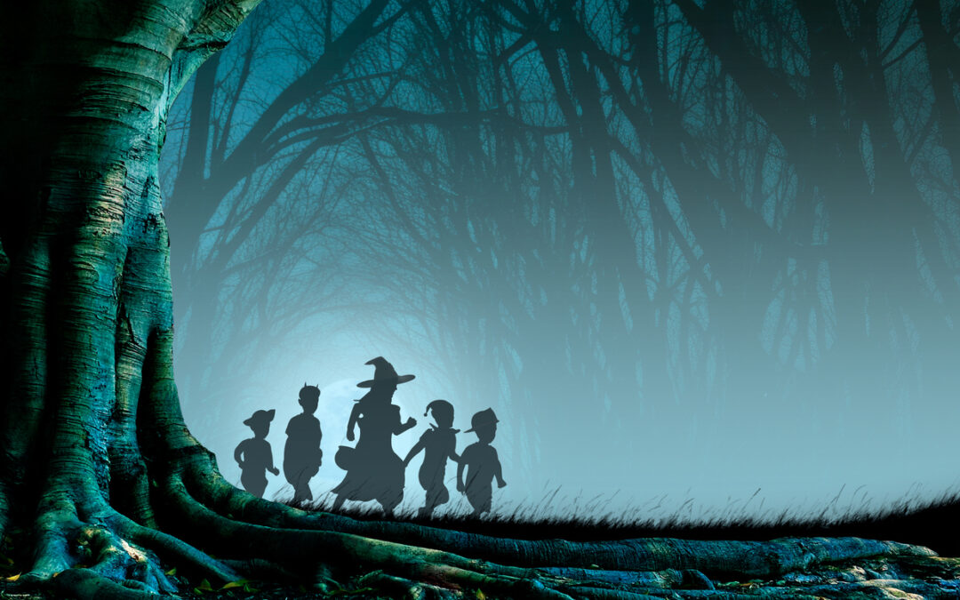 A group of silhouetted children march along on their trick-or-treat journey through a misty forest silhouetted by the glow of a rising full moon.